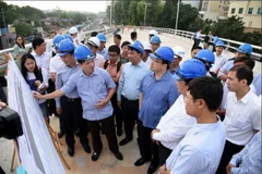 Bí thư Thành Ủy Hà Nội Hoàng Trung Hải đang kiểm tra thực tế tại Dự án cầu vượt nút giao An Dương và mở rộng đường đê Nghi Tàm. (Ảnh: Nguyễn Văn Cảnh/TTXVN)