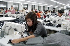 Công nhân sản xuất đồ may mặc. (Ảnh: Phạm Kiên/TTXVN)