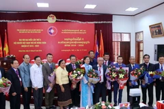 Ban chấp hành mới Khóa X của Hội người Việt Nam thủ đô Viêng Chăn chụp ảnh lưu niệm với các quan chức tham dự đại hội. (Ảnh: Phạm Kiên/TTXVN)