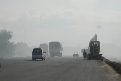 Các phương tiện tham gia giao thông trong khói bụi. (Ảnh: Công Thử/TTXVN)