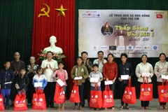 Lãnh đạo tỉnh Quảng Trị cùng lãnh đạo của Trung ương Hội Bảo vệ quyền trẻ em Việt Nam và Hội người khuyết tật, Nạn nhân da cam và bảo vệ quyền trẻ em Việt Nam tỉnh tặng học bổng cho các học sinh có hoàn cảnh khó khăn. (Ảnh: Trịnh Bang Nhiệm/TTXVN)