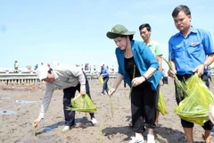 Chủ tịch Quốc hội Nguyễn Thị Kim Ngân tham gia trồng cây ở xóm Mũi xã Đất Mũi. (Ảnh: Trọng Đức/TTXVN)