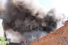 Khói lửa bao chùm nhà xưởng sản xuất. (Ảnh: Huyền Trang/TTXVN)