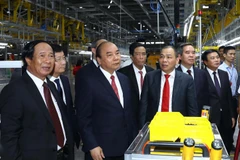 Thủ tướng Nguyễn Xuân Phúc và các đại biểu thăm xưởng lắp ráp Nhà máy sản xuất ôtô Vinfast. (Ảnh: Thống Nhất/TTXVN)