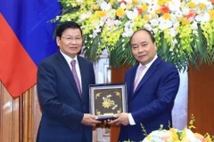 Thủ tướng Nguyễn Xuân Phúc tặng quà lưu niệm cho Thủ tướng Lào Thongloun Sisoulith. (Ảnh: Thống Nhất/TTXVN)
