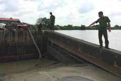 Lực lượng chức năng bắt giữ tàu công suất lớn đang chứa cát được bơm hút trái phép trên sông Đồng Nai. (Ảnh: Sỹ Tuyên/TTXVN)