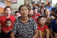 Bà Nguyễn Thị Hoa (mẹ tiền đạo Công Phượng) chăm chú theo dõi và cổ vũ cho đội tuyển Olympic Việt Nam. (Ảnh: Tá Chuyên/TTXVN)