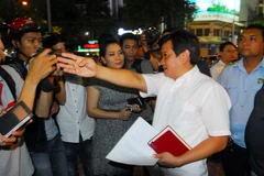 Ông Đoàn Ngọc Hải, Phó Chủ tịch UBND quận 1 chỉ rõ ranh giới vi phạm lấn chiếm vỉa hè của một chủ hộ kinh doanh. (Ảnh: Mạnh Linh/TTXVN)