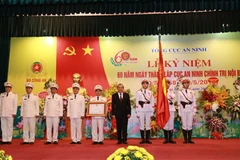 Thừa ủy quyền Chủ tịch nước, Phó Thủ tướng Thường trực Chính phủ Trương Hòa Bình gắn và trao Bằng Huân chương Chiến công hạng Ba lên lá cờ truyền thống của Cục An ninh chính trị nội bộ. (Nguồn: Bộ Công an)