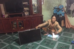hị Trần Thị Tịnh, thôn 3, xã Nghĩa Hòa, huyện Chư Păh bên cạnh chiếc tivi hỏng do rớt từ trên kệ xuống do rung chấn mạnh khi tuyến đường đang thi công ngang qua nhà. (Ảnh: Hồng Điệp/TTXVN)