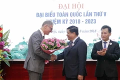 Ngài Wolfgang Manig, Đại biện Lâm thời Đại sứ quán Cộng hòa Liên bang Đức tại Việt Nam tặng hoa tân Chủ tịch Hội Hữu nghị Việt Nam-Đức, ông Nguyễn Chí Dũng. (Ảnh: Văn Điệp/TTXVN)