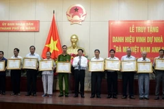 Phó Bí thư thường trực Thành ủy Đà Nẵng Võ Công Trí trao danh hiệu 'Mẹ Việt Nam Anh hùng' cho thân nhân các Mẹ đã mất. (Ảnh: Đinh Văn Nhiều/TTXVN)