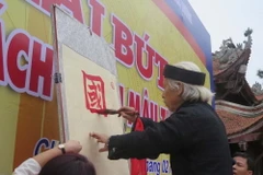 Nghệ nhân thư pháp khai 4 chữ Nho: Quốc, Phú, Dân, Cường thể hiện niềm tin vào sự lớn mạnh, hưng thịnh của quốc gia, dân tộc. (Ảnh: Mạnh Minh/TTXVN)