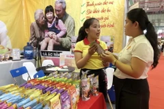 Giới thiệu sản phẩm với khách tham quan tại triển lãm. (Ảnh: Mỹ Phương/TTXVN)