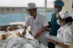 Bệnh nhân Nguyễn Văn Họa điều trị phục hồi chức năng tại Khoa ngoại tổng quát Bệnh viện đa khoa Long Khánh. (Ảnh: Lê Xuân/TTXVN)