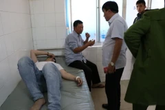 Hai cha con bị trúng đạn phải nhập viện cấp cứu. (Ảnh: Đặng Tuấn/TTXVN)