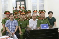 Bị cáo Phan Văn Anh Vũ (áo caro) và đồng phạm nghe tòa tuyên án. (Ảnh: Doãn Tấn/TTXVN)