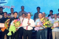 Thủ tướng Nguyễn Xuân Phúc trao giải A cho các tác giả Cuộc vận động sáng tác ca khúc Kỷ niệm 50 năm chiến thắng Đồng Lộc-Những đóa hoa bất tử. Ảnh: Thống Nhất/TTXVN)