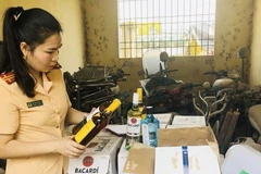  540 chai rượu ngoại không có giấy tờ hợp lệ bị lực lượng cảnh sát giao thông bắt giữ. (Ảnh: Trịnh Duy Hưng/TTXVN)