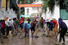 Giáo viên và phụ huynh học sinh tổng dọn vệ sinh tại trường Tiểu học thị trấn Mường Xén, huyện Kỳ Sơn, Nghệ An. (Ảnh: Tá Chuyên/TTXVN)