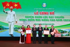 Phó Thủ tướng Trần Lưu Quang (thứ 3, trái sang) trao Quyết định của Thủ tướng Chính phủ công nhận Huyện nông thôn mới nâng cao cho lãnh đạo huyện Xuân Lộc, Đồng Nai. (Ảnh: Lê Xuân/TTXVN)