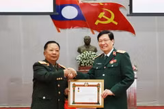 Phó Thủ tướng, Bộ trưởng Bộ Quốc phòng Lào, Đại tướng Chansamone Chanyalath trao Huân chương Lao động hạng Nhất cho Trung tướng, Phó Giáo sư-Tiến sỹ Nguyễn Xuân Kiên, Giám đốc Học viện Quân y Việt Nam. (Ảnh: Xuân Tú/TTXVN)