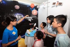 Giới thiệu cho học sinh kiến thức về khoa học vũ trụ tại Ngày hội STEM. (Ảnh: Anh Tuấn/TTXVN)