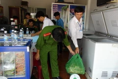 Công an Bình Phước kiểm tra thực phẩm bẩn tại cơ sở Tuyết Ánh, nơi cung cấp thực phẩm trong các bữa ăn cho công nhân của công ty. (Ảnh: Đậu Tất Thành/TTXVN)