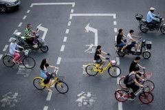 Người dân di chuyển bằng xe đạp tại Thượng Hải, Trung Quốc ngày 3/7. (Nguồn: AFP/TTXVN)