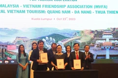 Đại diện Trung tâm Xúc tiến du lịch 3 tỉnh thành Quảng Nam-Đà Nẵng-Thừa Thiên Huế và Chủ tịch Hội Hữu nghị Malaysia–Việt Nam (giữa) ký kết biên bản ghi nhớ hợp tác truyền thông và quảng bá du lịch. (Ảnh: An Nguyễn/TTXVN)