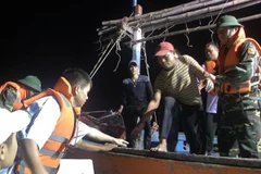 Bộ đội Biên phòng Quảng Bình tiếp nhận 6 ngư dân trên tàu cá gặp nạn. (Ảnh: TTXVN phát)