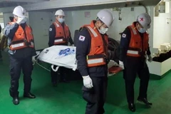 Nhân viên cứu hộ chuyển một thi thể được tìm thấy gần khu vực chìm của tàu Daeseong. (Nguồn: Yonhap)