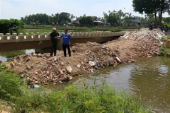 Người dân đổ đất lấp ngang đoạn kênh qua địa bàn thôn Điền Chánh Trung. (Ảnh: Phước Ngọc/TTXVN)