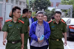 Cảnh sát dẫn giải bị cáo đến tòa. (Ảnh: Văn Điệp/TTXVN)