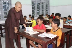 Sư cô Thích Nữ Đức Thịnh với các em học sinh trong lớp học tình thương. (Ảnh: Nguyễn Thành/TTXVN)