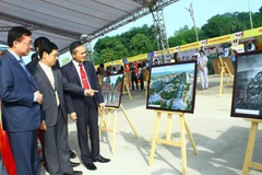 Các đại biểu tham quan Triển lãm ảnh ''Tình hữu nghị đoàn kết đặc biệt Việt Nam-Lào''. (Ảnh: Tá Chuyên/TTXVN)