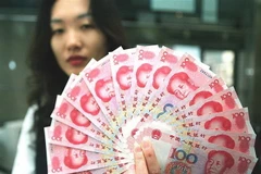 Nhân viên ngân hàng kiểm tiền giấy mệnh giá 100 nhân dân tệ mới của Trung Quốc. (Ảnh: AFP/TTXVN)
