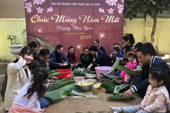 Gói bánh chưng tại Tết cộng đồng. (Ảnh: Việt Khoa/TTXVN)