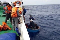 Lực lượng kiểm ngư trên tàu KN 410 đưa các ngư dân lên tàu. (Ảnh: TTXVN phát)