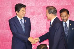 Tổng thống Moon Jae-in (phải) bắt tay Thủ tướng Nhật Bản Abe Shinzo. (Nguồn: Yonhap)