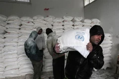 Người tị nạn Palestine nhận lương thực cứu trợ tại Khan Yunis, Dải Gaza. (Ảnh: AFP/TTXVN)