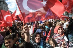 Những người ủng hộ Tổng thống Tayyip Erdogan vẫy quốc kỳ trong chiến dịch vận động tranh cử ở Istanbul, Thổ Nhĩ Kỳ ,ngày 30/3. (Ảnh: AFP/TTXVN)