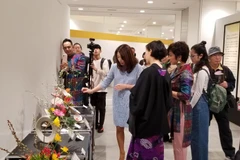Nghệ nhân Ikenobo Mika, thành viên gia tộc Ikenobo, đang đánh giá các tác phẩm của nghệ nhân Ngọc Linh. (Ảnh: Cẩm Tuyến/Vietnam+)