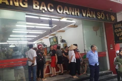 Người dân vây quanh cửa hàng vàng bạc Oanh Vân 1. (Ảnh: Trọng Lịch/Vietnam+)