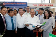 Thủ tướng Nguyễn Xuân Phúc thăm các gian hàng trưng bày tại hội nghị. (Ảnh: Thống Nhất/TTXVN)