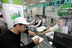 Khách hàng giao dịch tại Vietcombank. (Ảnh: Trần Việt/TTXVN)