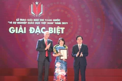Bộ trưởng Bộ Giáo dục và Đào tạo Phùng Xuân Nhạ và giáo sư-tiến sỹ Raymond Gordon - đại diện Trường Đại học Anh Quốc Việt Nam trao giải Đặc biệt cho đại diện nhóm tác giả tác phẩm "Chuyện về những người thầy thắp lửa". (Ảnh: Thanh Tùng/TTXVN)