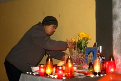 Anh Trần Văn Chung lập bàn thờ vợ ở trước cửa lối vào cửa hàng đã niêm phong. (Ảnh: Trần Quang Vinh/Vietnam+)