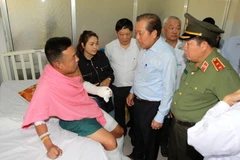 Phó Thủ tướng Thường trực Chính phủ Trương Hoà Bình thăm hỏi, động viên Đại úy Trần Tuấn Thanh bị thương trong khi làm nhiệm vụ đang được điều trị tại Bệnh viện Chợ Rẫy. (Ảnh: Thanh Vũ/TTXVN)
