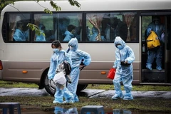 Đoàn xe chở các công dân về khu cách ly tập trung theo dõi COVID-19. (Ảnh: TTXVN)